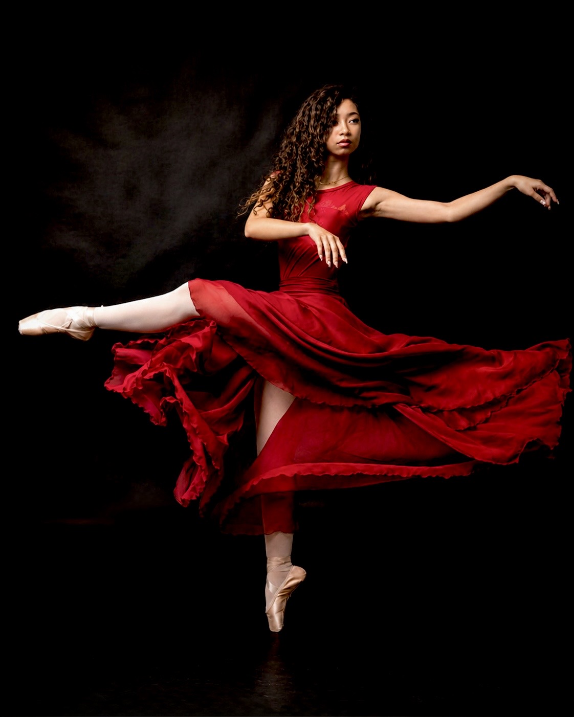 Inaya Malik en pointe in a flowing red dress